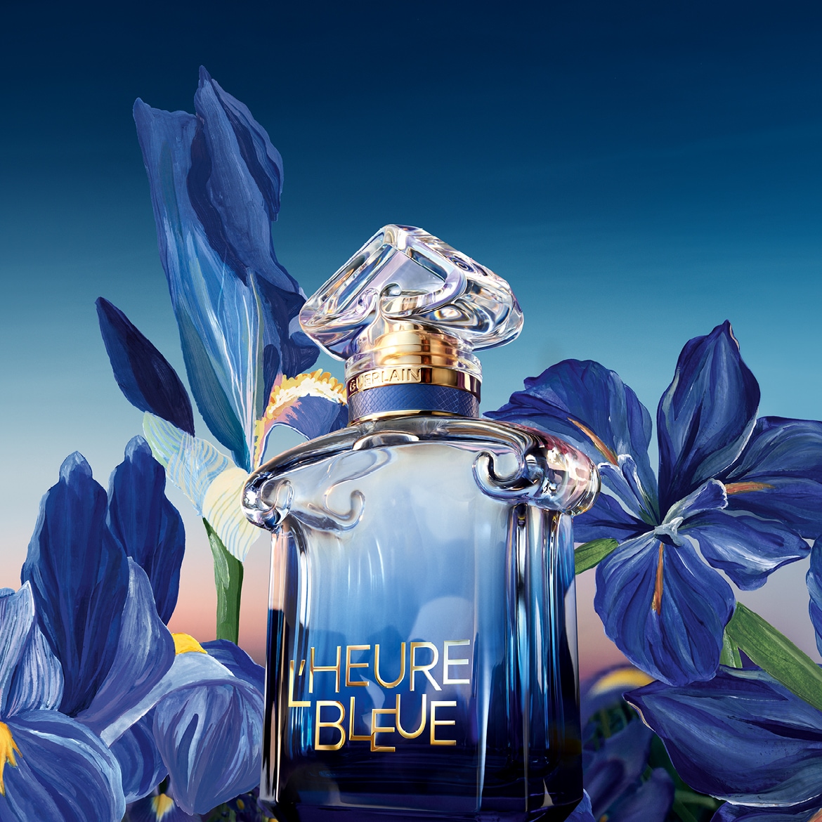 Parfém L'Heure Bleue od Guerlain v elegantním flakonu s modrým přechodem a zlatým nápisem, obklopený modrými květy kosatců, evokuje klidnou atmosféru soumraku.