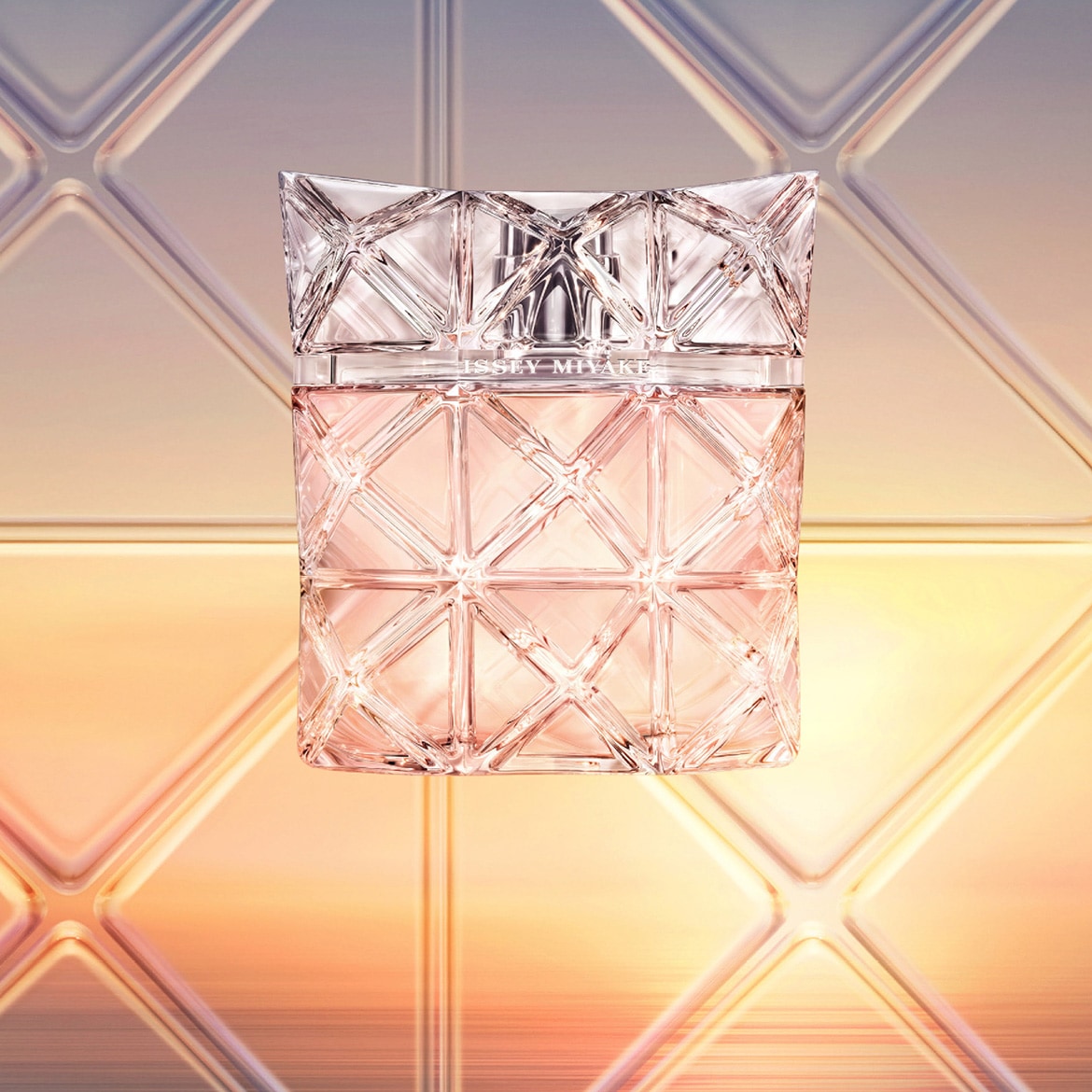 Lahvička parfému Issey Miyake s geometrickým designem a průhledným víčkem, odrážející světlo a eleganci.