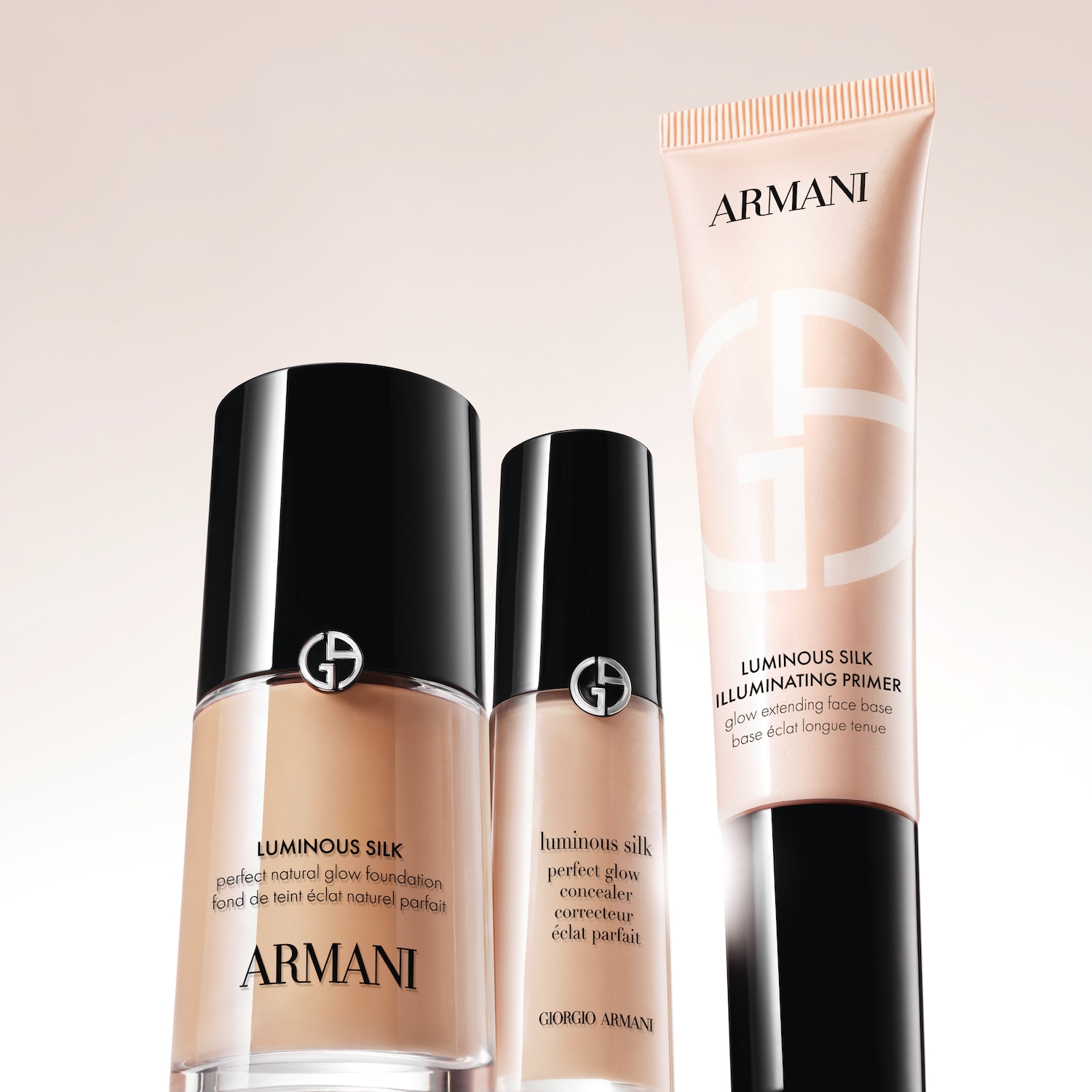 Tři produkty Armani Luminous Silk: make-up, korektor a rozjasňující báze v béžových obalech s černými detaily pro dokonalý přirozený vzhled.