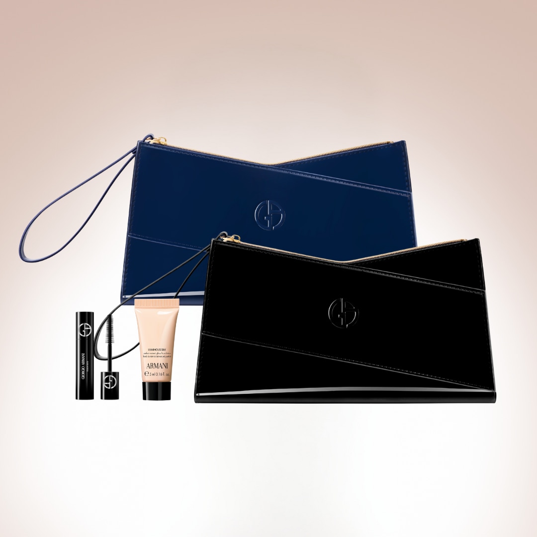 Dva elegantní lesklé psaníčka Giorgio Armani, jedno tmavě modré a druhé černé, doplněné o řasenku a bázi pod make-up.