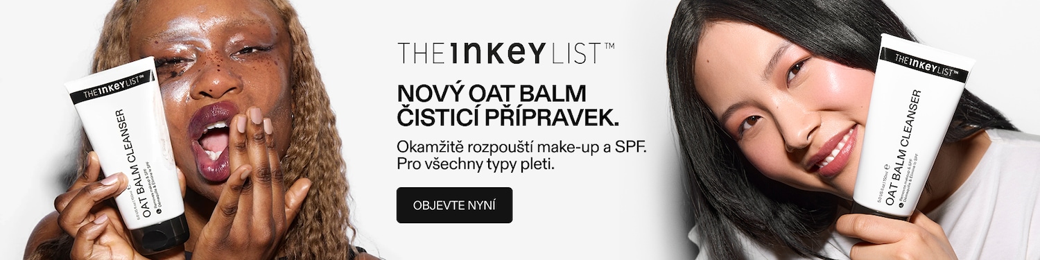Žena s lesklými rty a mokrými vlasy drží bílou tubu The Inkey List Oat Balm Cleanser, která odstraňuje make-up a SPF.