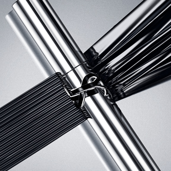 Černá stuha je uvázaná na stříbrné trubce, která se kříží s černými lany.